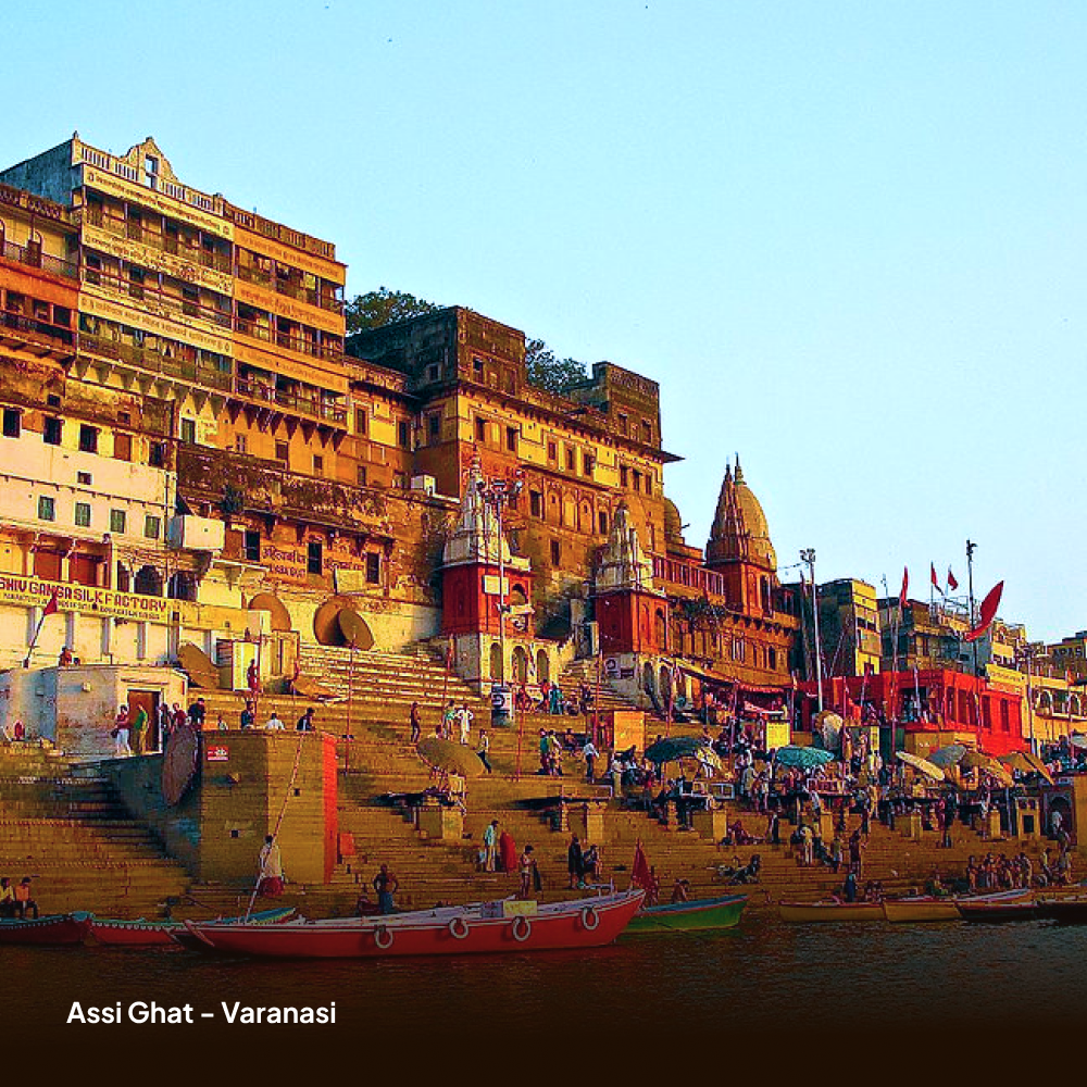 Assi Ghat in Varanasi with people and boats on the steps.